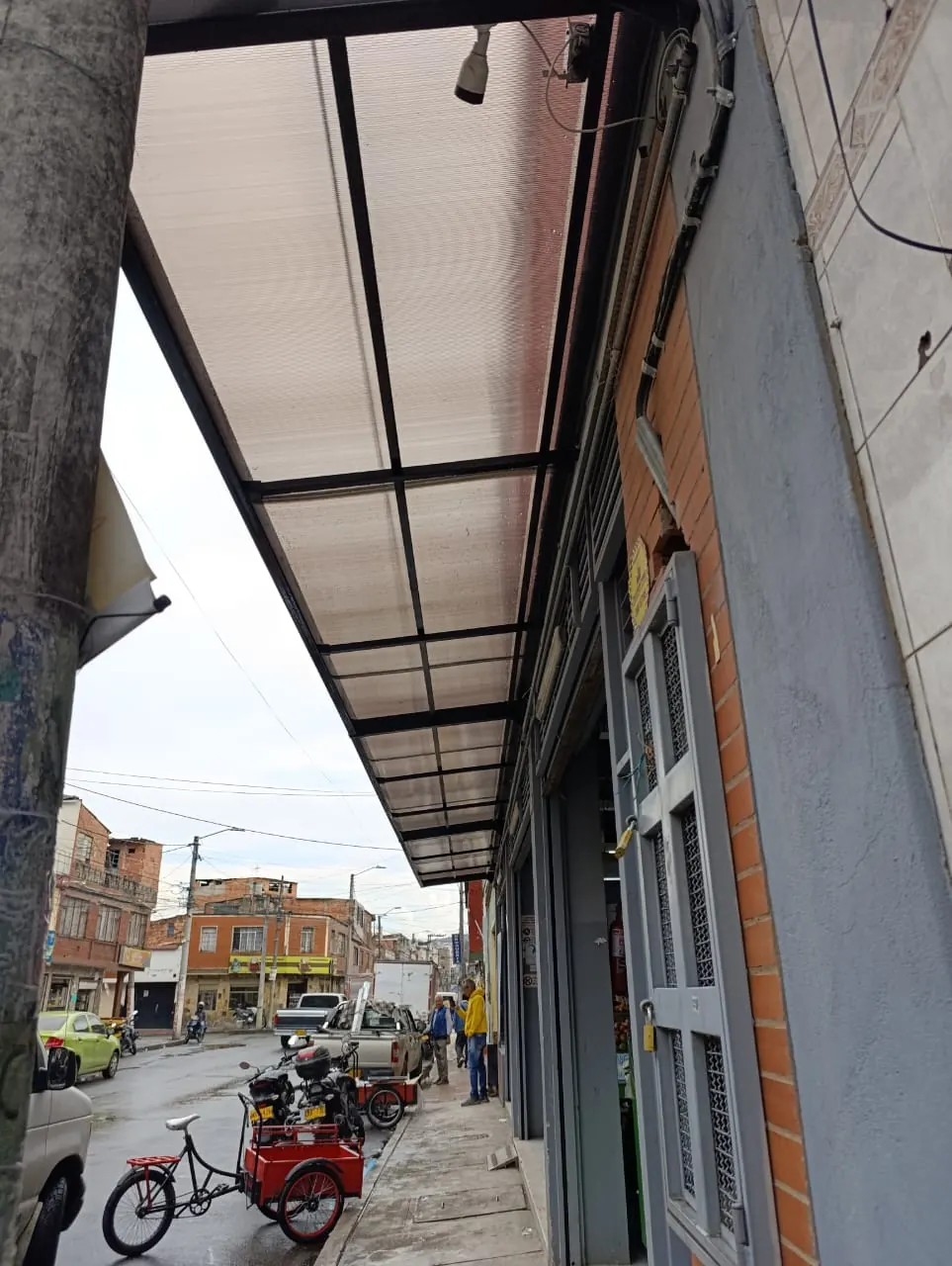 Cubierta metálica translúcida instalada en un acceso exterior